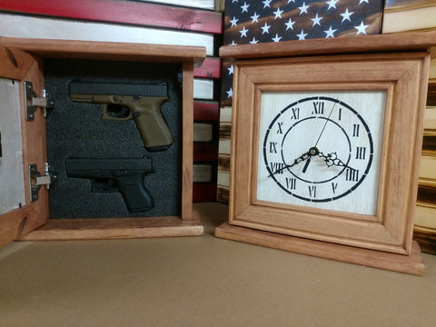 Two wooden gun concealment clocks sitting next to one another, one of which has it's hidden compartment open to reveal two handguns.