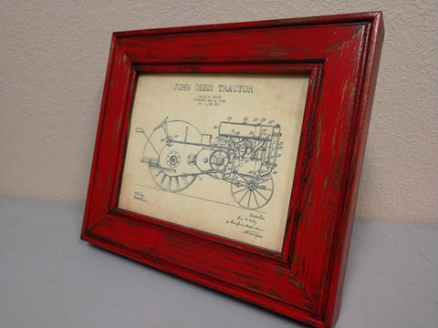 An 8x10 distressed red gun concealment picture frame with a diagram of a John Deer tractor inside.
