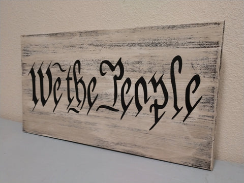 "We the People" white wooden gun concealment box leaning against wall.
