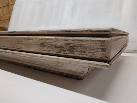 A small wooden gun concealment wall mantle, with distressed white paint. 
