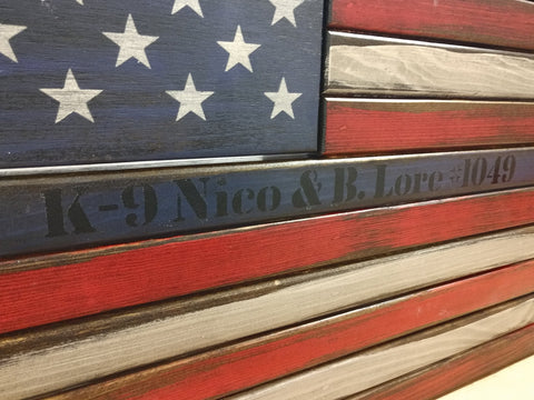 An American gun concealment flag with the words "K-9 Nico & B. Lore #1049" painted in black.