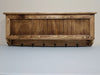 A gun concealment coat rack with six black metal hooks made from wood and finished with brown stain.