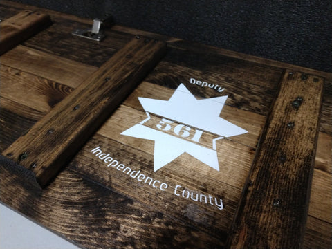 The inside of a wooden gun concealment sign with the Independence County Deputy painted in white. 