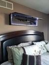 Hanging black gun concealment wall art opened to show shotgun in foam insert.