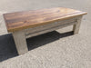 A distressed white wooden gun concealment coffee table with a sliding top.
