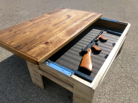 A distressed white wooden gun concealment coffee table with it's sliding top open to reveal a rifle.