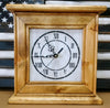 A golden Oak gun concealment clock with a white face and black roman numerals sitting in front of a black and white American concealment flag.