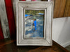 A 5x7 distressed white gun concealment picture frame with a picture of a little boy holding a rifle inside. 