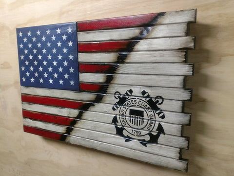 A closed wooden concealment flag with a standard US flag diagonally converts to white with a black stenciled coast guard logo