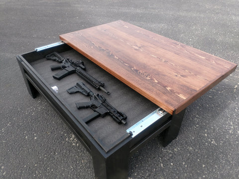 A black gun concealment coffee table with it's unpainted sliding top open to reveal two rifles.