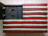 American flag gun concealment case with top left section open revealing a pistol, ammo clip, and a stitched American flag patch.
