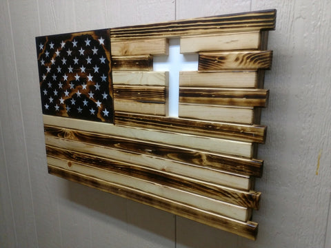 Burnt style American flag gun concealment case with light & dark brown wood stripes and a white cross carved into the upper right.