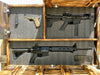 A charred wooden gun concealment flag with all 3 panels open with 2 rifles, a pistol, and 2 magazines held in place by foam lining