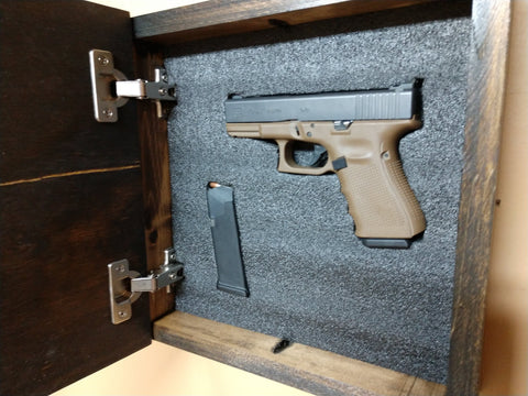 Interior of mini hidden gun storage box with handgun and ammunition inside.