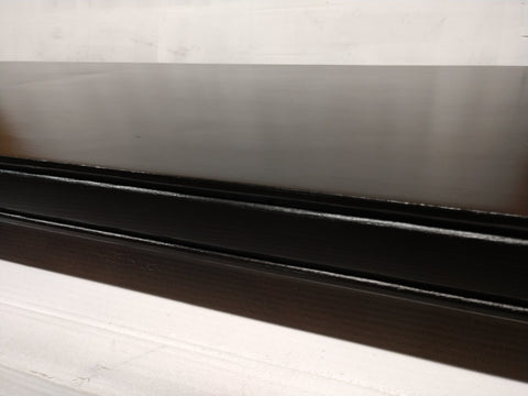 A wooden gun concealment shelf painted black. 