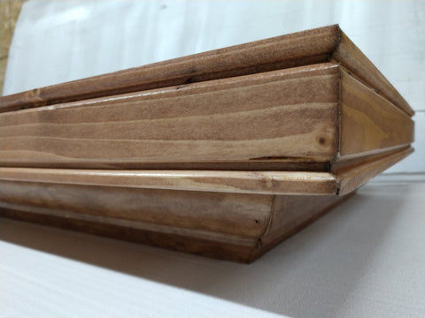 A gun concealment shelf with a cherry wood stain. 