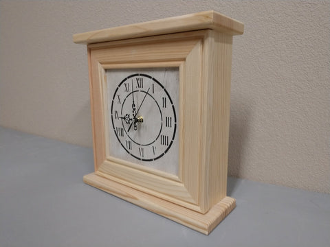 A gun concealment clock, with a white face and black roman numerals, made from natural, unfinished wood. 