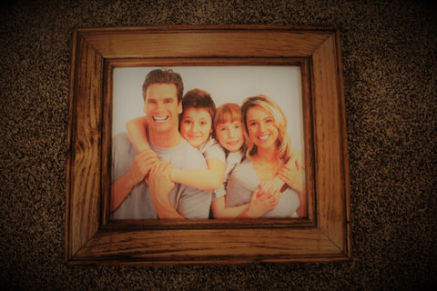 An 11x14 gun concealment picture frame, made from wood sitting on carpet flooring. 